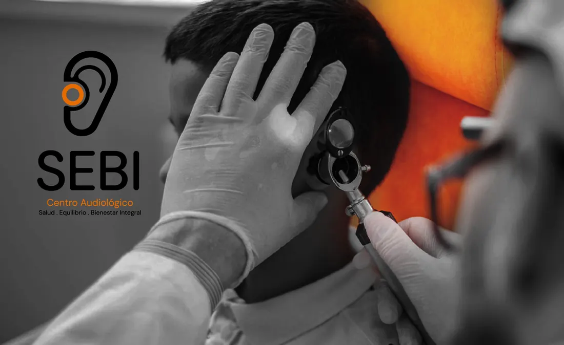 Profesional de SEBI examinando el oído de un paciente con un otoscopio durante una evaluación auditiva
